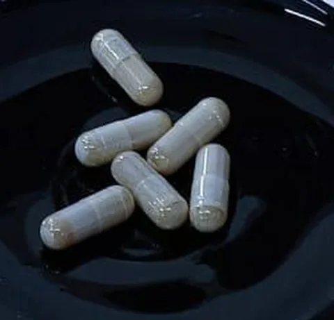 Light beige Diabeet capsules on a black saucer